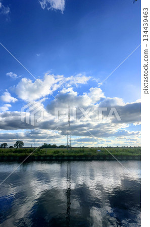 A Serene and Tranquil Reflection of Beautiful Clouds and Lush Landscape Over Calm Water 134439463