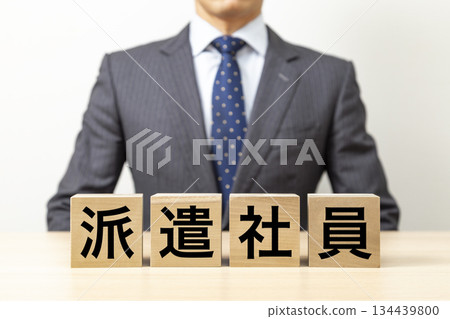 A block with the word "temporary employee" written on it and a businessman 134439800