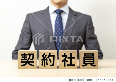一塊寫著「合約工」字樣的磚塊和一個商人 134439853