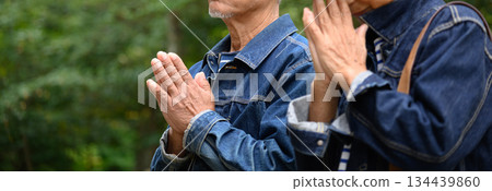 An elderly couple prays at a shrine An elderly couple prays at a shrine 134439860