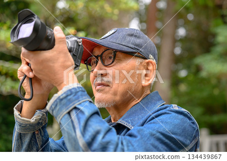 一位手持單眼相機的老人男子 134439867