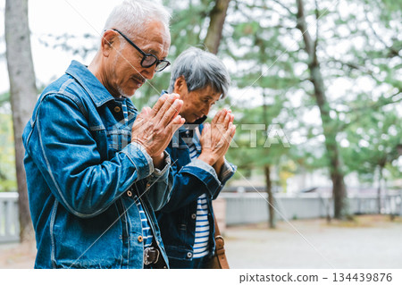 一對身著牛仔服的老夫婦在神社祈禱。 134439876