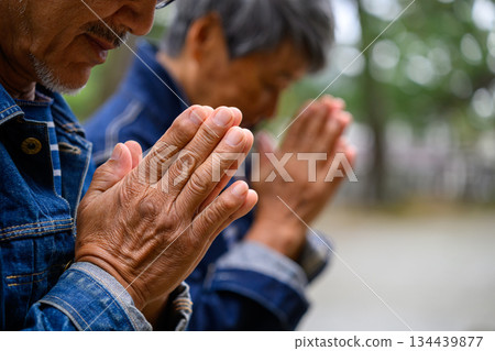 一對老夫婦在神龕前祈禱。 134439877