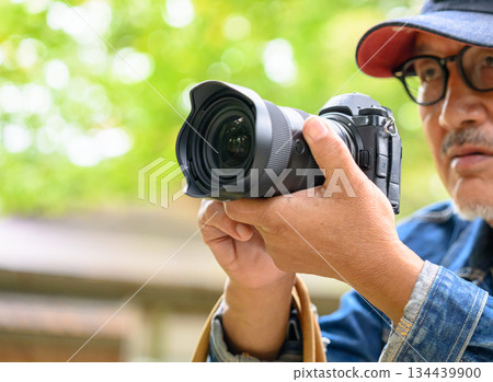 一位老人的手拿著相機,周圍是自然光。 一位老人的手拿著相機,周圍是自然光。 134439900