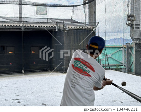 Dad playing baseball at a batting center 134440211