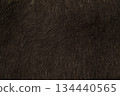 Close-up of dark brown faux fur or thick animal hair, often used for winter garments or home decor. 134440565