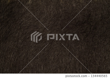 Close-up of dark brown faux fur or thick animal hair, often used for winter garments or home decor. 134440565