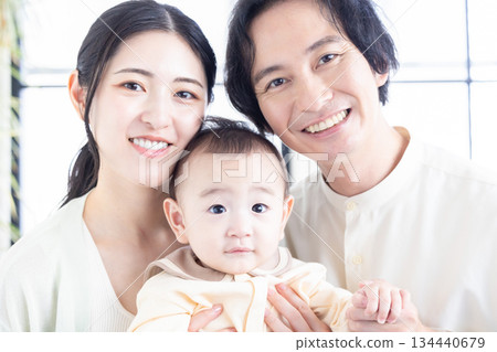 A couple holding a baby A couple holding a baby 134440679