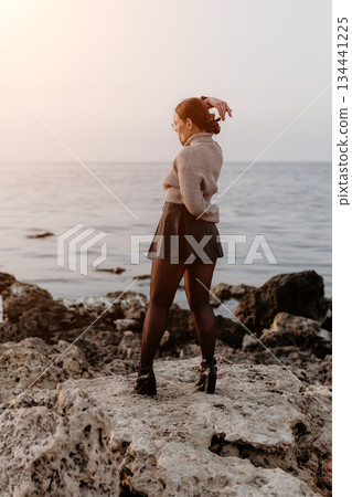 Woman Sea Sunset CoastalRocks FashionPhotography: Stylish woman poses seaside at sunset, showcasing fall fashion on rocky shore. Woman Sea Sunset CoastalRocks FashionPhotography: Stylish woman poses seaside at sunset, showcasing fall fashion on rocky shore. 134441225