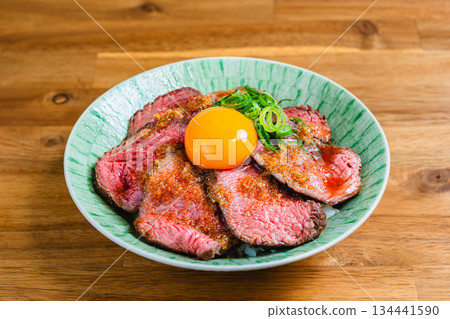 Roast beef bowl topped with egg yolk 134441590