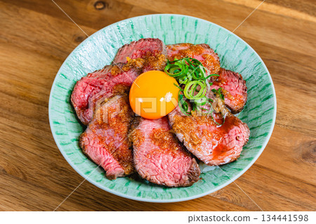 Roast beef bowl topped with egg yolk 134441598