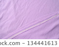 Purple fold knitted fabric background and texture.The fabric features a prominent vertical rib texture. 134441613