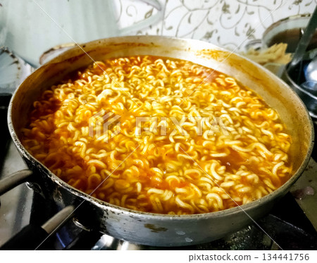 Instant noodles boiling in hot water in a steel pan Instant noodles boiling in hot water in a steel pan 134441756
