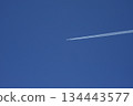 Airplane and contrail in the clear blue sky 134443577