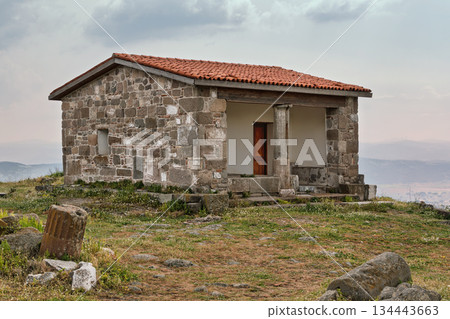 Stone building with red tiled roof and columns at Pergamon Acropolis, Bergama, Turkey 134443663