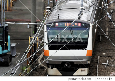 列車尾部和架設在鐵路線上方高架人行天橋上的電線 134445416