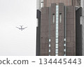 一架客機飛越摩天大樓的圍牆。 134445443