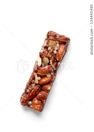Sweet nutty caramel bar with puffed rice on a white background. Sweet nutty caramel bar with puffed rice on a white background. 134445495
