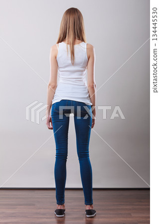 Girl full length in denim trousers white blank top rear view 134445530