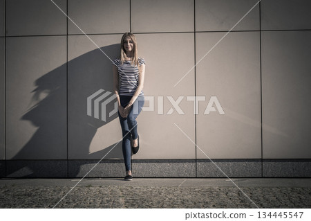 woman casual style against stone grunge wall woman casual style against stone grunge wall 134445547