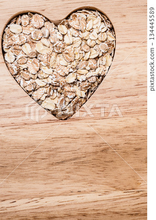Oat cereal heart shaped on wooden surface. 134445589