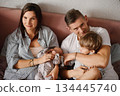 Happy Family Relaxing Together With Newborn Baby 134445740