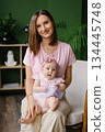 Tender Mother Holding Baby Girl In Pink Outfit 134445748