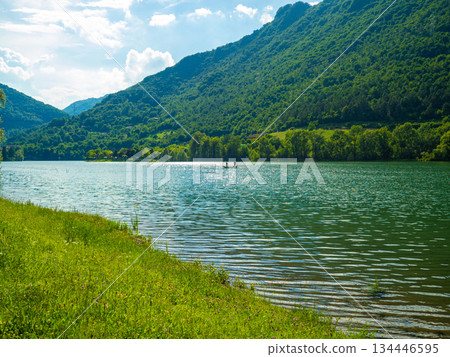 Serene Lake Idro Surrounded by Majestic Mountains and Cloudy sky, Italy, Crone Serene Lake Idro Surrounded by Majestic Mountains and Cloudy sky, Italy, Crone 134446595