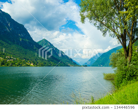 Serene Lake Idro Surrounded by Majestic Mountains and Cloudy sky, Italy, Crone Serene Lake Idro Surrounded by Majestic Mountains and Cloudy sky, Italy, Crone 134446596