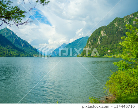 Serene Lake Idro Surrounded by Majestic Mountains and Cloudy sky, Italy, Crone Serene Lake Idro Surrounded by Majestic Mountains and Cloudy sky, Italy, Crone 134446710