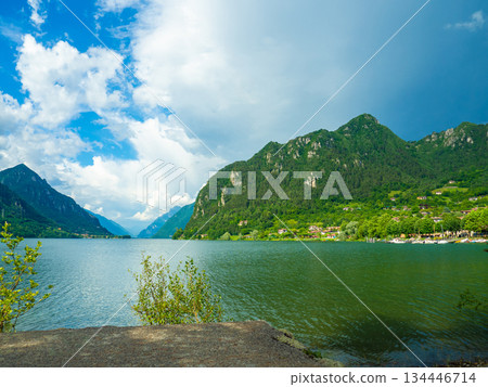 Serene Lake Idro Surrounded by Majestic Mountains and Cloudy sky, Italy, Crone Serene Lake Idro Surrounded by Majestic Mountains and Cloudy sky, Italy, Crone 134446714