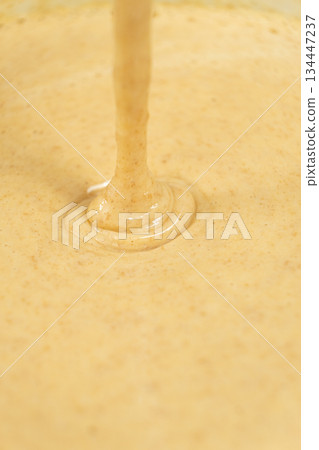 Texture of smooth creamy batter flowing down. Texture of smooth creamy batter flowing down. 134447237