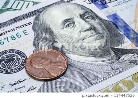 Coin one cent on the banknote of one hundred dollars close up Coin one cent on the banknote of one hundred dollars close up 134447526