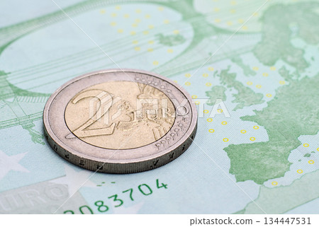 Coin two euros on the banknote of one hundred euro Coin two euros on the banknote of one hundred euro 134447531