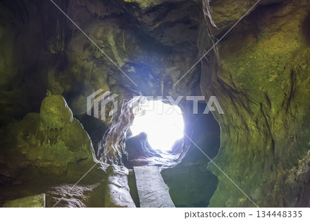 Inside view of the cave with light in the end of the tunnel 134448335