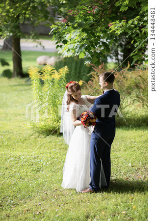 Young wedding couple dancing together on grassy lawn Young wedding couple dancing together on grassy lawn 134448481