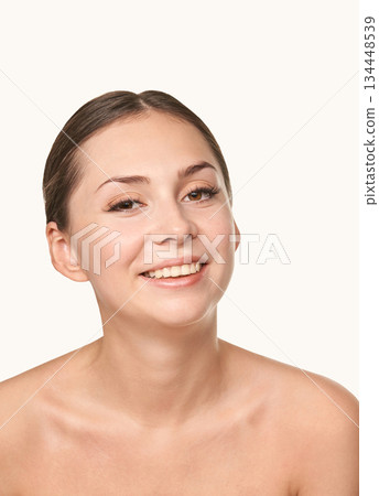 Young caucasian female smiling against neutral background Young caucasian female smiling against neutral background 134448539