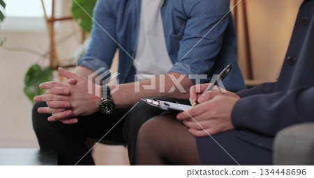 Therapist and discussion with patient, office or understanding of addiction or talking. Consultation, man and woman doctor with advice in rehab, communication and notes for process and therapy. 134448696