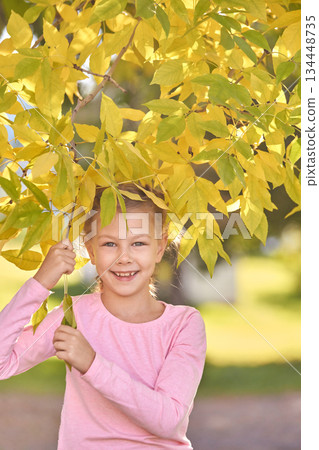 Happy caucasian young girl enjoying autumn outdoors under yellow leaves Happy caucasian young girl enjoying autumn outdoors under yellow leaves 134448735