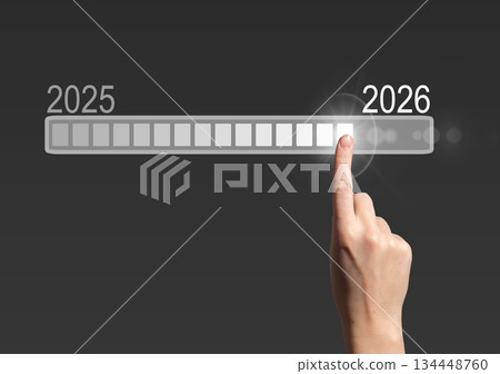 Loading bar progress. Female hand touching digital screen, symbol of 2025 to 2026 transition, 134448760