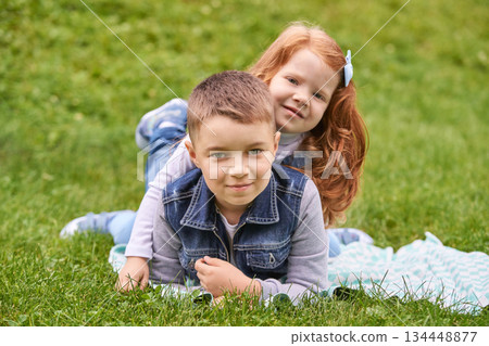 Young caucasian siblings playing on grass smiling and enjoying outdoor fun 134448877
