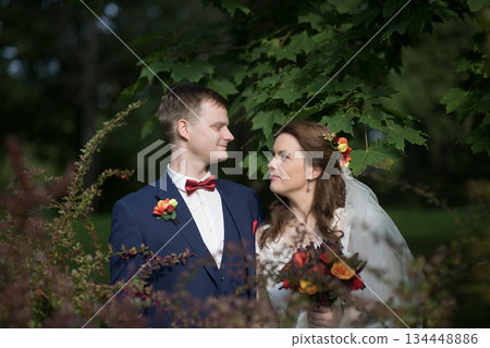 Wedding couple gazing at each other under leafy branches 134448886