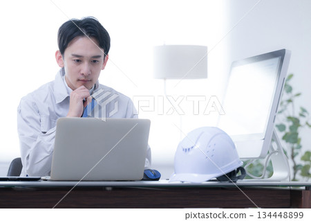 身穿工作服的工人在工地辦公室裡思考著。他們正在思考諸如訂貨、分包以及如何按時完成任務等策略。 134448899