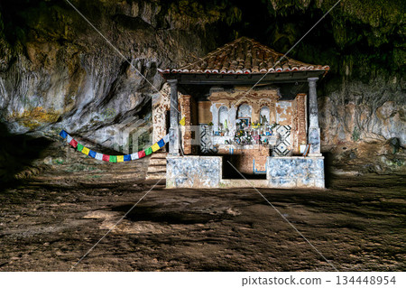 Dark interior of Lapa de Santa Margarida in Arrabida, Setubal, Portugal. Cave with small chapel of spontaneous worship 134448954