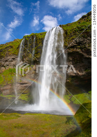Seljalandsfoss waterfall, flowing down the Seljalandssá River in the Nordic island nation of Iceland, with a rainbow 134449056