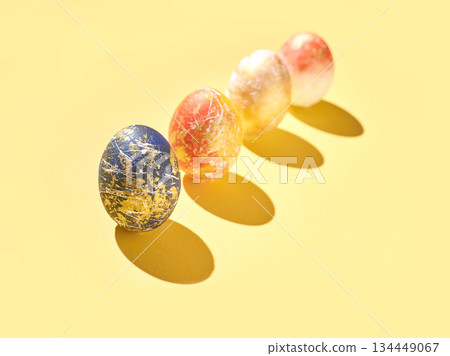 Colorful artistic easter eggs on yellow background with shadows Colorful artistic easter eggs on yellow background with shadows 134449067