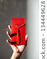 Hand holding red envelope with tassel. 134449628