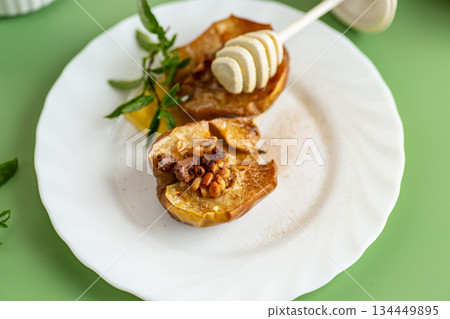 A cozy homemade dessert of baked apples with golden honey A cozy homemade dessert of baked apples with golden honey 134449895