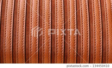 Striped brown leather texture with visible grain and stitching in natural warm tones. Natural background ideal for fashion, upholstery, bags, accessories, copy space 134450410