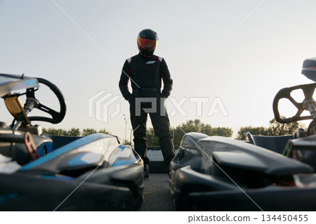 A drive racer is posing with cars near at the race 134450455